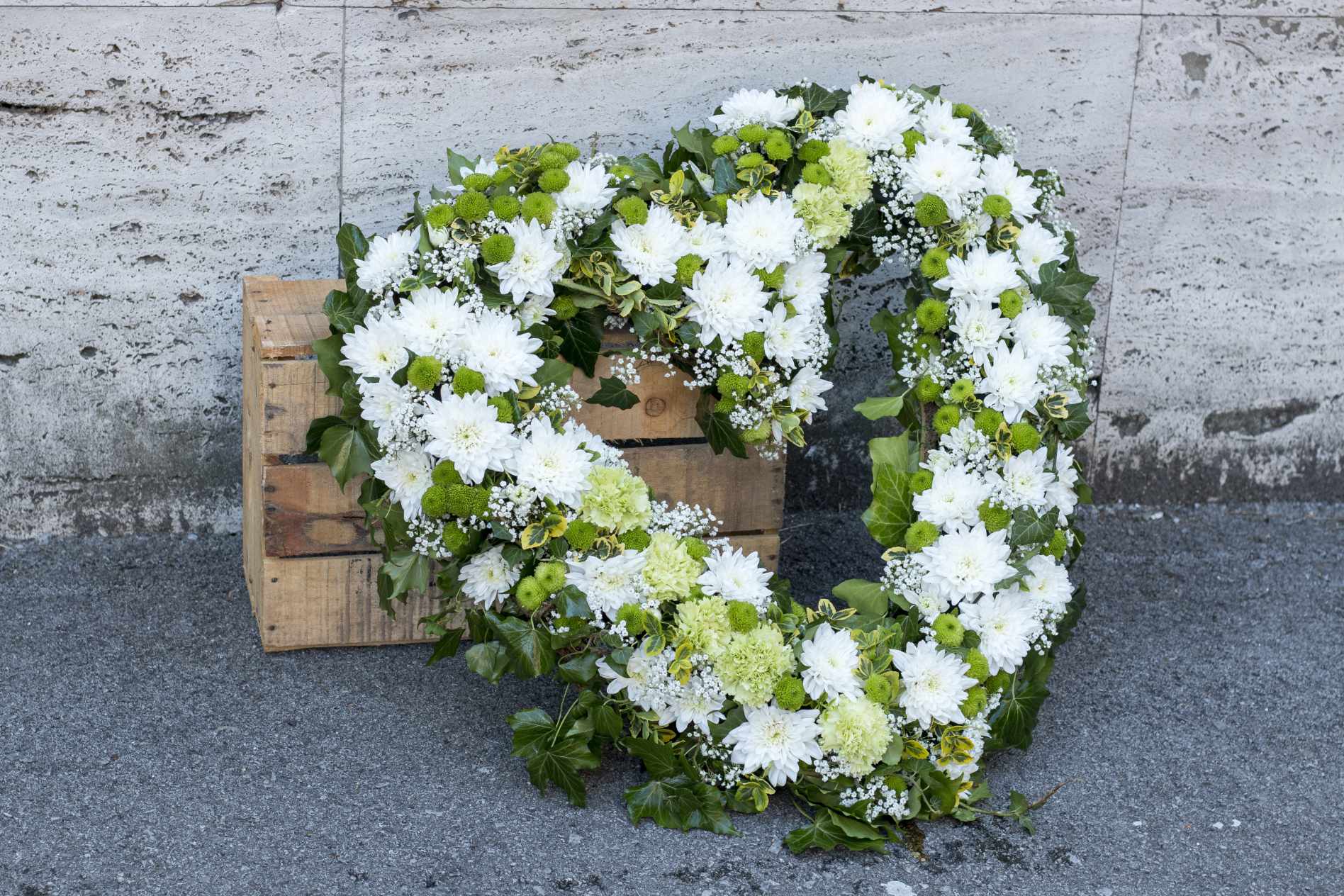 A large, white sympathy floral arrangement.